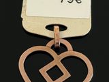 a close up of a metal tag with a heart on it