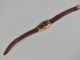 an image of a wrist watch with a gold case and red leather strap