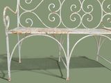 a white bench with a metal frame on a green background