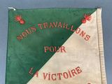 an old flag with a red and green design hanging on a wall