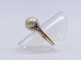 a close up of a ring with a pearl and diamonds on it