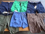 Plusieurs paires de shorts pour hommes sont alignées sur une table