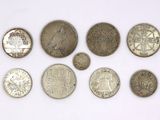 a group of silver coins sitting on top of a white surface