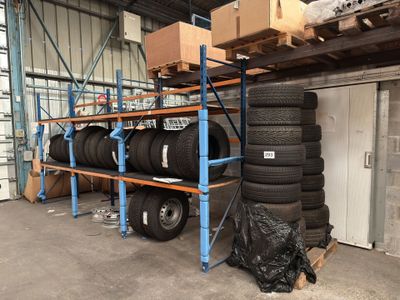 a lot of tires stacked on a rack in a warehouse