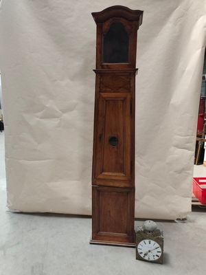 une grande horloge de parquet en bois posée à côté d'une petite horloge