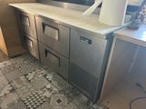 une photo d'une cuisine équipée d'appareils électroménagers en inox et d'un carrelage au sol