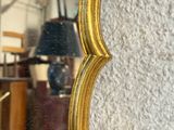 a mirror that has a gold frame on it
