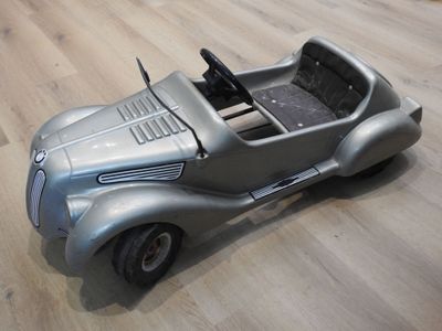 une petite voiture posée sur un plancher en bois