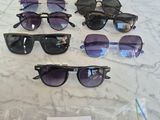 several pairs of sunglasses are on a table with a price tag