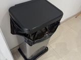 une poubelle posée par terre à côté d'une porte