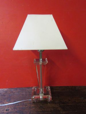 une lampe posée sur une table devant un mur rouge