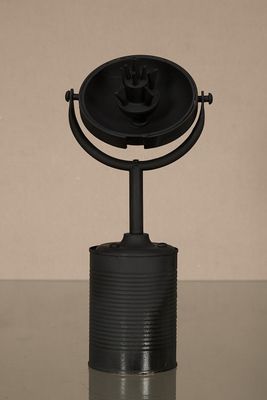 un objet noir posé sur une table, avec un mur marron en arrière-plan