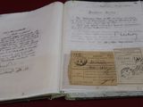 an old book with a lot of writing on it sitting on a table
