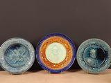 trois assiettes bleues et orange posées sur une table