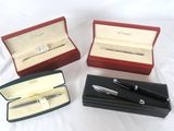 trois stylos et un stylo dans une boîte posée sur une surface blanche