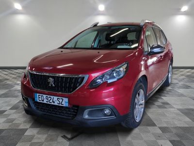 la voiture rouge est garée sur un sol en damier dans le garage