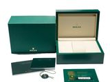 a green box with a watch and a keychain in it