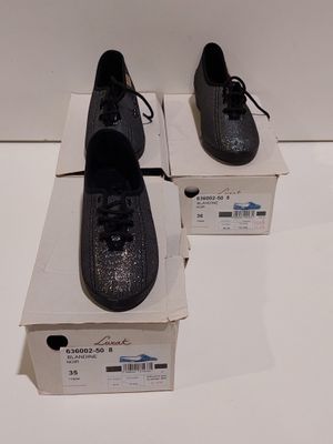 deux paires de chaussures noires posées sur une boîte