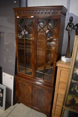 une armoire dotée d'une porte vitrée et d'un miroir