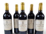 four bottles of wine are lined up on a white surface