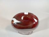 a glass vase with a red and white design on it