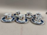 six tasses à café et leurs soucoupes sont posées sur une table