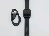 une Apple Watch noire avec un chargeur fixé dessus