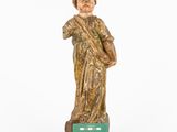 an old statue of a man holding a book and wearing a hat