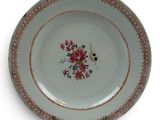 a plate with a floral design on it on a white surface