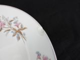 a white plate with pink flowers on it on a black background