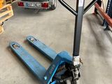 une photo d'un chariot élévateur dans un entrepôt, avec des palettes