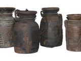 quatre vases posés les uns à côté des autres sur une surface blanche