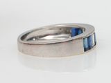 a close up of a ring with a blue stone in it