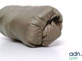 a sleeping bag on a white surface with a logo on it