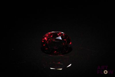a close up of a red diamond on a black surface