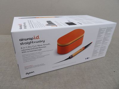 une boîte orange contenant un stylo, posée sur une table