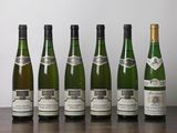 six bouteilles de vin sont alignées sur une table en bois