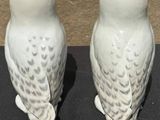 two white owls that are sitting on a table