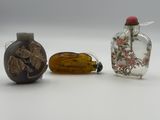 three small glass bottles sitting next to each other on a white surface