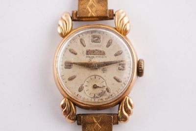 une montre-bracelet en or avec un bracelet en cuir marron