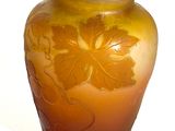 a vase that has a flower on it on a white surface