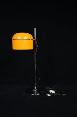 a yellow table lamp on a black background with a black background