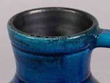 a blue vase that has a handle on it