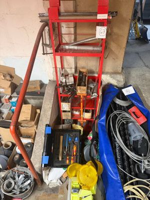 une échelle rouge posée à côté d'un tas d'objets divers