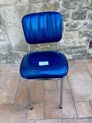 une chaise bleue posée sur un sol carrelé
