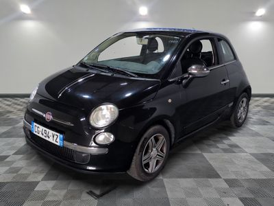 la photo d'une petite voiture noire sur un sol en damier