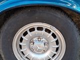 a close up of a blue truck with a flat tire