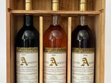 trois bouteilles de vin dans un coffret en bois muni d'une poignée en corde