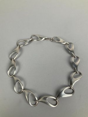 a close up of a silver bracelet on a table