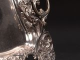 a silver plate with a handle on a black background